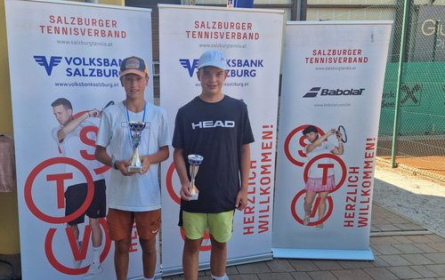 Tennisspieler mit Pokalen vor Bannern des Salzburger Tennisverbandes in Salzburg