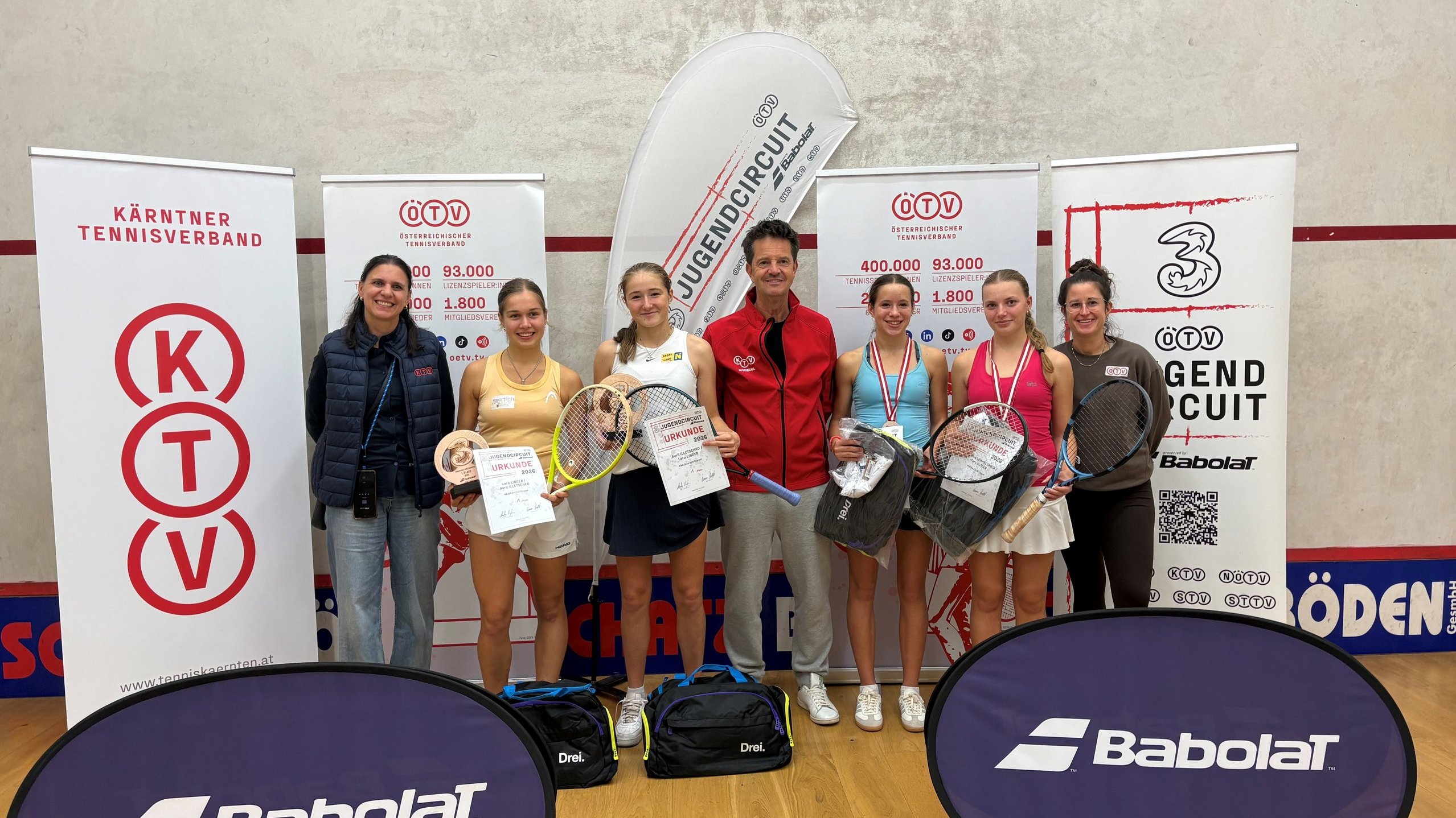 Jugendtennisspielerinnen und Funktionäre mit Urkunden und Schlägern in Kärnten.